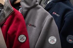 Detail of fleece jackets with embroidered brand logo and warm polar fleece texture
