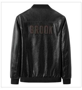 Detail of black faux leather jacket featuring brown BROOK applique embroidery on the back