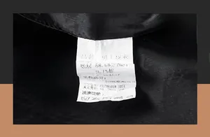 Close-up of the wash care label showing material composition on a black leather jacket