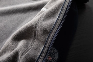 Detail of high-density gray fleece jacket with navy zipper and Norway flag patch