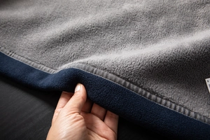 Detail view of thickened navy polar fleece jacket with warm grey fleece lining and trim