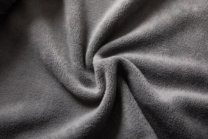 Macro texture of soft dark grey thick polar fleece fabric for warm outdoor jackets