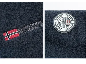 Detail of Norway flag embroidery and rubber badge on navy blue outdoor fleece jacket