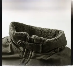 Detail of army green winter jacket featuring a fleece-lined stand collar and windproof strap