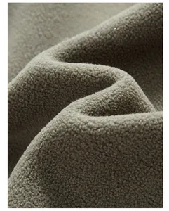 Close-up of thick beige fleece fabric texture showing soft fiber details and ripples