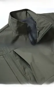 Detail of olive green outdoor vest showing stand collar, zipper pocket and mesh lining