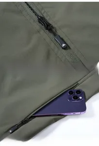 Detail of waterproof taped zipper and side pocket for large smartphone on green vest