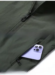 Detail of dark green hooded jacket showing durable zipper and a practical storage pocket