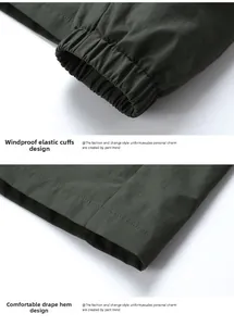 Detail of dark green windproof jacket showing elastic cuffs and smooth hem stitching