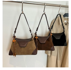 Close-up of retro suede crossbody bags with wooden bead tassels and premium metal hardware