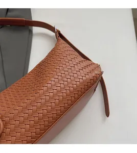 Detailed view of the caramel brown woven leather texture and side profile of the hobo bag