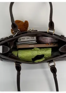Top view of spacious brown tote interior with folding umbrella, phone, and daily essentials