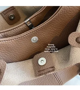 Dettaglio della borsa a secchiello in pelle martellata marrone con chiusura magnetica