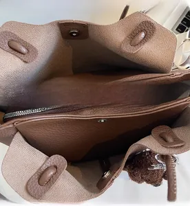 Dettaglio della borsa a secchiello in pelle marrone con zip e chiusura magnetica