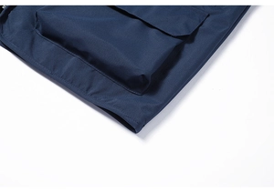 Detail of navy blue waterproof fishing vest showing 3D pocket and reinforced stitching