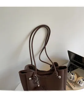 Dettaglio della borsa tote in pelle marrone scuro con fibbia in metallo argento
