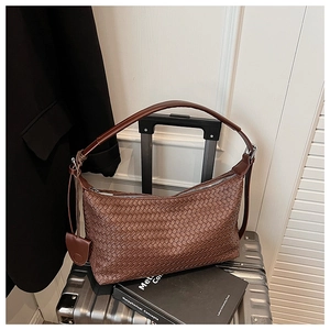 Close-up of the woven leather texture and silver zipper on the brown hobo shoulder bag