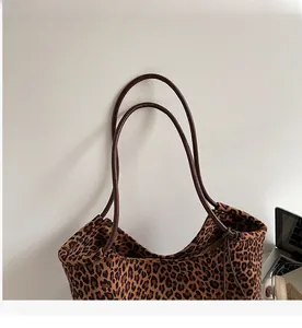 Detail der Wildleder-Einkaufstasche mit Leopardenmuster, braunen Griffen und viel Platz