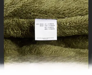 Dettaglio fodera in pile verde ed etichetta di lavaggio 100% poliestere della giacca
