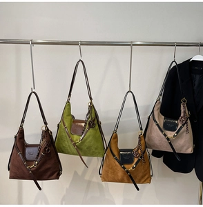 Close-up of suede Hobo bags in brown and olive green with metal ring buckles