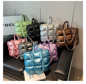 Selection of colorful quilted puffer tote bags in glossy nylon on a stylish leather sofa