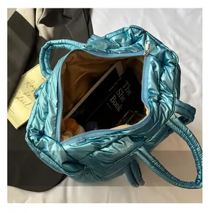 Macro view of blue metallic puffer bag showing large capacity interior and lining
