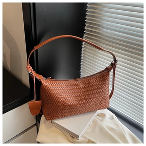 Detailed view of brown woven hobo bag featuring knotted shoulder strap and metal zipper