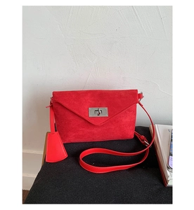Detail der roten matten Wildleder-Umschlagtasche mit einem silbernen Drehverschluss