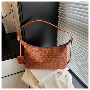 Detail of caramel orange woven leather hobo bag with zip closure and premium texture