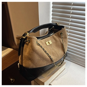 Close-up of diamond quilted pattern on a beige and black dual-tone tote bag with chain strap