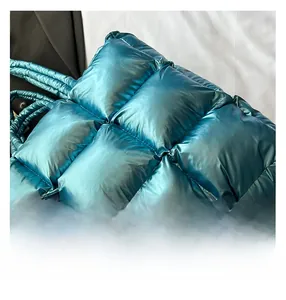 Close-up of quilted puffer tote bag in metallic blue with thick padded handles