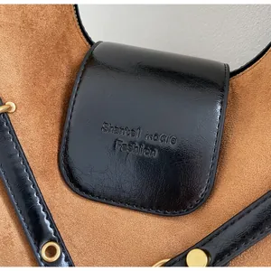 Detail of black glossy leather tote with brown suede lining and gold eyelets hardware