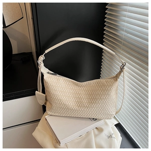 Detailed view of cream woven hobo bag with top zipper and knotted strap design
