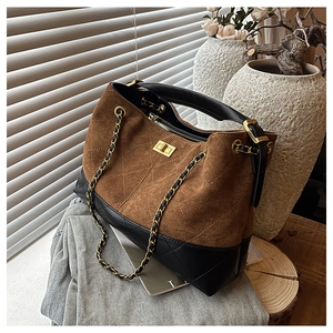 Close-up of quilted suede shoulder bag with classic chain strap and gold twist lock