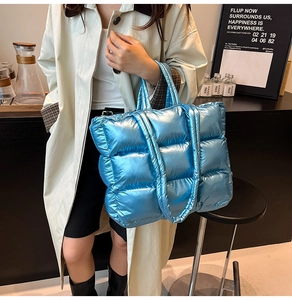 Detail showing the quilted puffer bag texture in electric blue with metallic finish