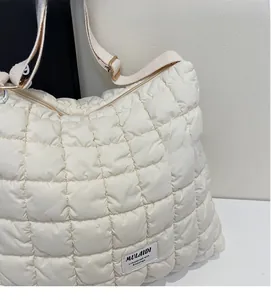 Detail of a beige quilted cloud bag showing the fabric texture and MULAIDI brand label