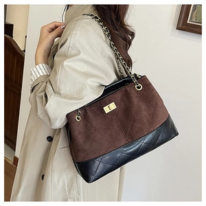 Detail of quilted leather patchwork and golden twist lock on retro chain shoulder bag