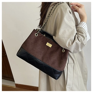 Close-up of diamond quilted pattern and gold twist lock on the bicolor leather tote