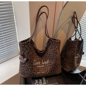 Detail der Wildleder-Einkaufstasche mit Leopardenmuster und braunen Ledergriffen