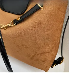 Detail of vintage brown suede tote with black leather strap and gold buckle hardware