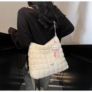 Close-up of quilted puff shoulder bag with plush bunny charm and beaded detail