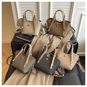 Detailed view of bucket bags with woven texture and metallic studs in various earth tones