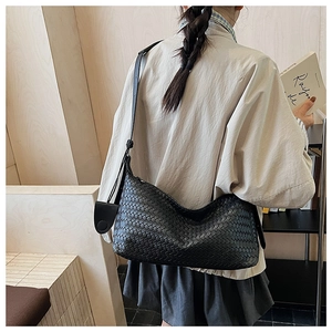 Detail of the black leather woven texture and hobo style on a crossbody bag