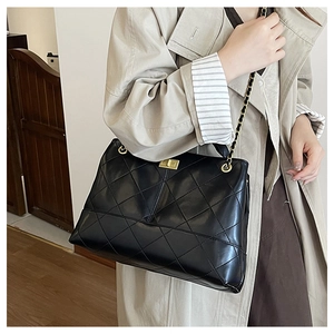 Detail of black quilted leather shoulder bag with gold square twist lock and chain strap