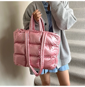 Chic pink quilted puffer tote bag shown on shoulder against a neutral interior background