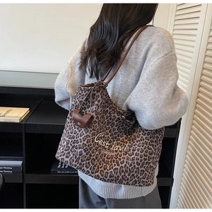 Makro-Detail der Wildleder-Tragetasche mit Leopardenmuster und braunen Lederriemen