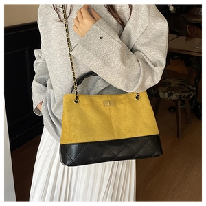 Detail of rhombic quilted stitching on a two-tone suede and leather chain shoulder bag