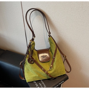 Detail of vintage green suede tote bag with brown leather straps and metal hardware buckle