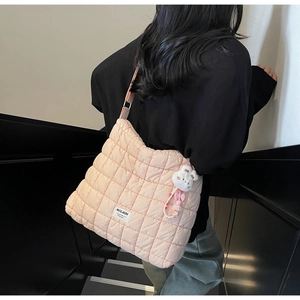 Detail of pink quilted puffer tote bag with MULAIDI label and cute rabbit charm