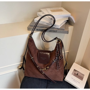 Detailed close-up of dark brown suede tote bag with leather trim and vintage hardware